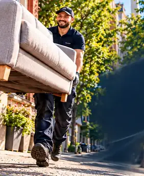 Helfer trägt ein Sofa zum Transport